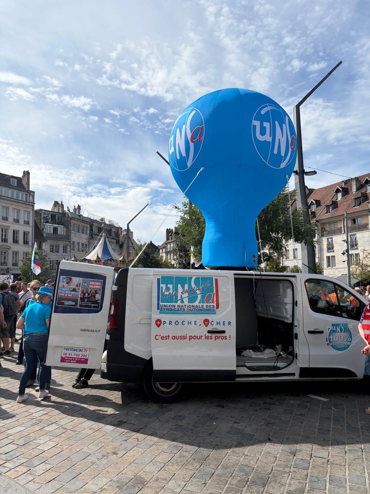 Ballon bleu UNSA au-dessus du camion syndical dans le rassemblement.